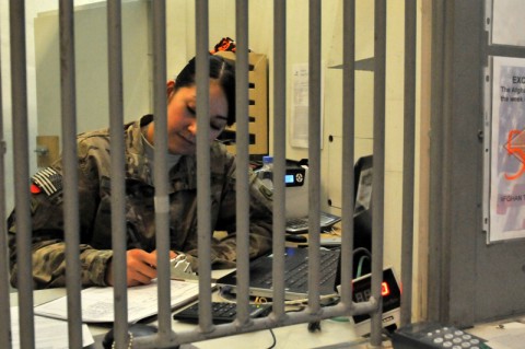 Spc. Nicoll C. Flores, a native of Woburn, Mass., and a cashier with the 101st Financial Management Support Detachment fills out the exchange transaction record to withdraw money as part of a transaction for a soldier, Nov. 4, 2013, at Bagram Air Field, Parwan province, Afghanistan. With this form a soldier can withdraw money to exchange Afghani currency to U.S. dollars or vice versa. The 101st Financial Management Support Detachment is a Massachusetts National Guard Unit. (Sgt. Sinthia Rosario/U.S. Army)