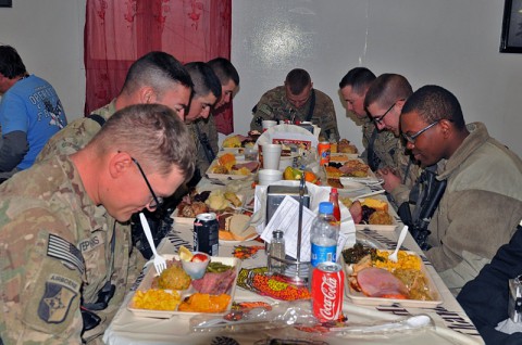 Task Force Lifeliner soldiers bow their heads and give thanks during Thanksgiving Day at the Koele Dining Facility, Nov. 28th, 2013, at Bagram Air Field, Parwan province, Afghanistan. The soldiers had the opportunity to celebrate their holiday with a variety of traditional foods. (U.S. Army photo by Sgt. Sinthia Rosario, Task Force Lifeliner Public Affairs)