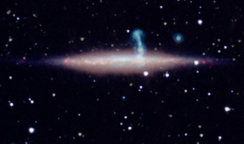 The edge-on spiral galaxy UGC 10288 appeared to be a single object in previous observations. However, new detailed radio data from the NRAO's Jansky Very Large Array (VLA) revealed that the large perpendicular extension of UGC 10288's halo (blue) is really a distant background galaxy with radio jets. (VLA/NASA/JPL-Caltech/SDSS/NOAO/University of Manitoba)