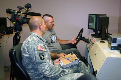 Former UFC fighter Chuck Liddell drives a Humvee simulator as Capt. Brady Hassell assists during a simulated convey Nov. 4. 2013 at the Warrior Resiliency and Recovery Center on Fort Campbell, Ky. where Hassell currently receives treatment for a traumatic brain injury. Liddell, along with fellow UFC guest fighters Forrest Griffin, Fredson Paixao and Jim Miller, received a hands-on tour of portions of TBI therapy sessions that Soldiers receive at the center. In 2014, the WRRC will become a National Intrepid Center of Excellence satellite site, known as the Intrepid Spirit. (U.S. Army Photo by Laura Boyd)