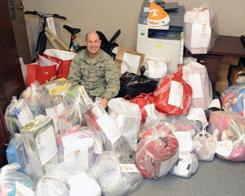 Brig. Gen. Donald Johnson, Assistant Adjutant General - Air, Tennessee National Guard, sits among the mass of items the Tennessee National Guard Joint Force Headquarters staff members collected to support the Salvation Army's annual Angel Tree Program. (Master Sgt. Robin Olsen, TN National Guard Joint Public Affairs.)