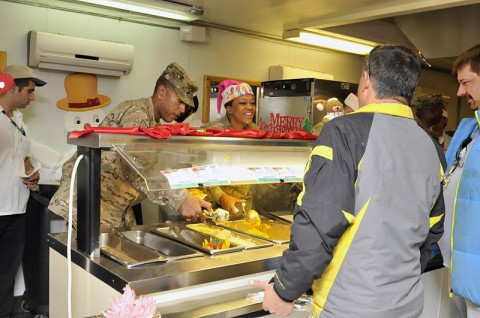 Task Force Lifeliner’s Col. Charles R. Hamilton, a native of Houston, Texas, and commander of the 101st Sustainment Brigade, 101st Airborne Division (Air Assault), and Master Sgt. Katherine E. Lawson-Best, a native of New Orleans, LA, and human resources administration noncommissioned officer in charge, serve meals during Christmas lunch, Dec. 25, 2013 at the Koele Dining Facility at Bagram Air Field, Parwan province, Afghanistan. As tradition has it, senior military leaders served their troops a feast worthy of the Holiday. (U.S. Army photo by Sgt. Sinthia Rosario, Task Force Lifeliner Public Affairs)
