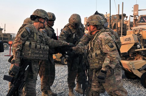 Soldiers with 2nd Platoon (Lancers), 51st Transportation Company, 77th Combat Sustainment Support Battalion, in support of Task Force Lifeliner, gather around in a team huddle after prepping their mine resistant ambush protected vehicle as part of preparation for upcoming missions, Dec. 22, 2013 at Bagram Air Field, Parwan province, Afghanistan. (U.S. Army photo by Sgt. Sinthia Rosario, Task Force Lifeliner Public Affairs)