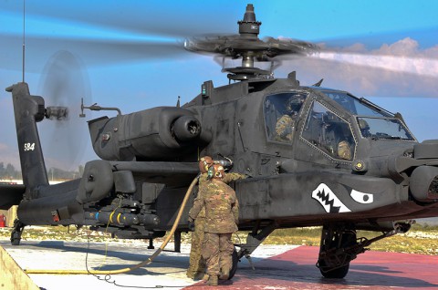 Task Force Attack Soldiers with the 159th Combat Aviation Brigade conduct a hot refuel on an AH-64D Apache helicopter. ( Spc. Joseph Green)