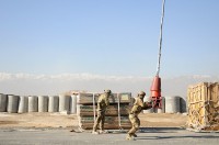 Spc. Hanook M. Chi (right), a native of Seoul, South Korea, grabs and pulls a cargo hook slung down from a contracting aircraft towards Spc. Vonza Abney (left), a native of Hinesville, Ga., as they prepare to hook up sustainment supplies during sling load operations, Jan. 6, 2014 at Bagram Air Field, Parwan province, Afghanistan.  (Sgt. Sinthia Rosario, Task Force Lifeliner Public Affairs)