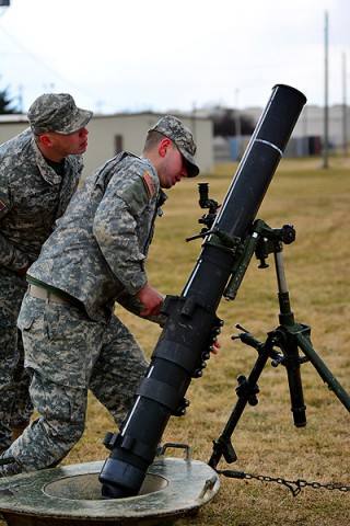 Pfc. Zachary R. Hoggard, a mortarman with Headquarters and Headquarters Company, 1st Battalion, 327th Infantry Regiment, 1st Brigade Combat Team, 101st Airborne Division, moves to position his 120 mm mortar tube into position while Spc. Daniel J. Saldivar, an assistant gunner with Company B, 1st Battalion, 327th Infantry Regiment, observes during gunner preparedness training Jan. 15 at Johnson Field. (Sgt. 1st Class John Brown)