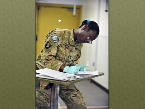 Capt. Christine Shepherd, brigade nurse with Company C, 801st Brigade Support Battalion, 4th Brigade Combat Team, 101st Airborne Division, writes patient information for an Afghan patient at the Forward Operating Base Salerno, Afghanistan, Combat Support Hospital on July 14, 2013. (U.S. Army photo by Maj. Kamil Sztalkoper, 4th Brigade Combat Team Public Affairs)