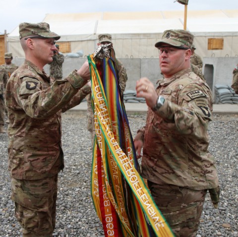 Strike transfer of authority ceremony U.S. Army Col. Peter Benchoff, commander of Task Force Strike, and Command Sgt. Maj. Brendan Haywood, Task Force Strike's sergeant major, unfurl the unit colors during a transfer of authority ceremony March 3, 2014 at Forward Operating Base Gamberi. (Sgt. David Cox/U.S. Army)