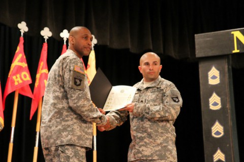 Sgt. Michael Nunes, a gunner with Battery B, 2nd Battalion, 320th Field Artillery Regiment, 1st Brigade Combat Team, 101st Airborne Division, receives his Charge of the Noncommissioned Officer from Command Sgt. Maj. Brian Veney, the command sergeant major of 426th Brigade Support Battalion, during 2nd Bn., 320th FAR's NCO Induction Ceremony March 20 at the Morale, Welfare and Readiness' Dale Waryrnen Recreation Center. (Sgt. Jon Heinrich/U.S. Army)