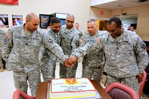 The command sergeants major and first sergeants cut the cake after conducting a noncommissioned officer induction ceremony for 16 soldiers from 2nd Battalion, 320th Field Artillery Regiment, 1st Brigade Combat Team, 101st Airborne Division, March 20 at the Morale, Welfare and Readiness' Dale Waryrnen Recreation Center. (Sgt. Jon Heinrich/U.S. Army)