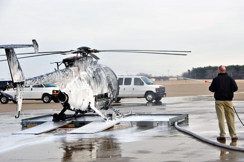 Attendees at the United States Army Special Operations Aviation Command's Corrosion symposium observed a demonstration of the 160th Special Operations Aviation Regiment (Airborne) aircraft bird bath. The bird bath is meant to knock the residue off of an aircraft once it returns from flight and reduce the chance of corrosion. (U.S. Army photo by Staff Sgt. Thaddius S. Dawkins II, United States Army Special Operations Aviation Command)