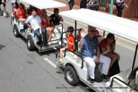 Festival Director Jessica Goldberg (right front) rides with the former Festival Director Doug Barber and other dignitaries  in the Children’s Parade at the 2014 Rivers and Spires Festival in Historic Downtown Clarksville