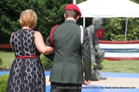 A ROTC cadet escorts a family member after placing a rose at the Montgomery County War Memorial