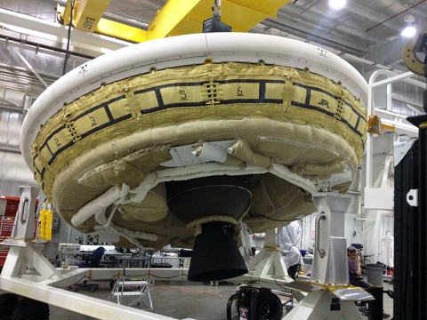 A saucer-shaped test vehicle holding equipment for landing large payloads on Mars is shown in the Missile Assembly Building at the US Navy's Pacific Missile Range Facility in Kaua'i, Hawaii. (NASA/JPL-Caltech) A saucer-shaped test vehicle holding equipment for landing large payloads on Mars is shown in the Missile Assembly Building at the US Navy's Pacific Missile Range Facility in Kaua'i, Hawaii. (NASA/JPL-Caltech)