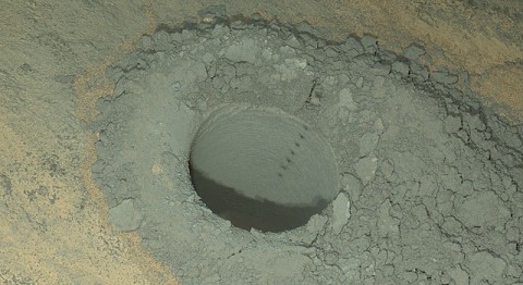 The Mars Hand Lens Imager on NASA's Curiosity Mars rover provided this nighttime view of a hole produced by the rover's drill and, inside the hole, a line of scars produced by the rover's rock-zapping laser. The camera used its own white-light LEDs to illuminate the scene on May 13, 2014. (NASA/JPL-Caltech/MSSS)