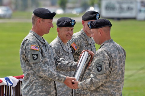 Maj. Gen. James C. McConville (left), outgoing commanding general, 101st Airborne Division (Air Assault), is presented with a ceremonial artillery shell casing as a memento as Gen. Daniel B. Allyn (center), commanding general, U.S. Army Forces Command, looks on during a change of command ceremony, June 20, 2014, at Fort Campbell, Ky. (U.S. Army photo by Larry Noller)