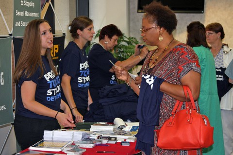 Wanda Jobe, a contractor who works on Fort Campbell, accepts a PTSD Awareness Day shirt and asks Samantha Rogers, from Military Pathways, questions about PTSD resources June 25, 2014 at Blanchfield Army Community Hospital. "I think that I may have an undiagnosed case of PTSD myself and I am working through my own issues," said Jobe. "Hopefully this information will help me work through what I'm going though and maybe I can use it to help my friends." (U.S Army photo by Stacy Rzepka)