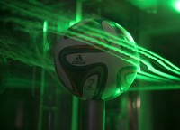 A close up of the Brazuca ball in Ames’ Fluid Mechanics Laboratory’s two-foot by two-foot wind tunnel. Smoke highlighted by lasers visualizes air flow around the ball. (NASA’s Ames Research Center)