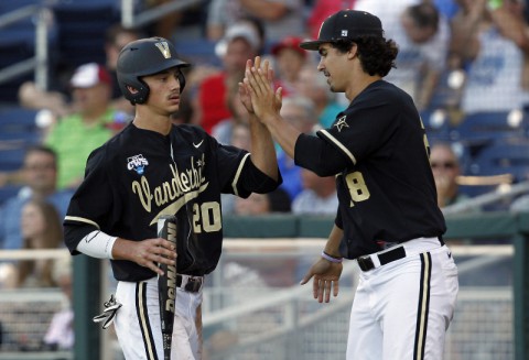 Vanderbilt Commodores runner Bryan Reynolds (20) celebrates his run with pitcher Jared Miller (28) against the Texas Longhorns during game thirteen of the 2014 College World Series at TD Ameritrade Park Omaha. (Bruce Thorson-USA TODAY Sports)