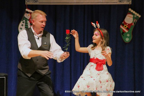 Magician Russ Nowack astounds a young girl with one of his magic tricks