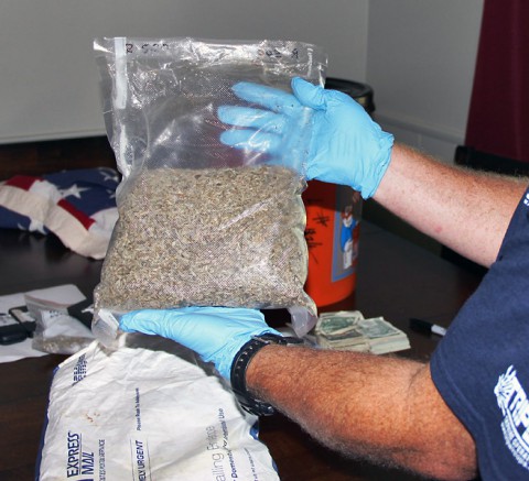 A Drug Task Force agent holds up a bag of synthetic marijuana found at the home of Robert Joseph Nolen.