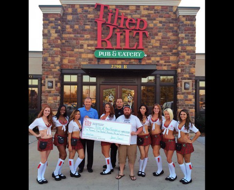 Folds of Honor Vice President of Corporate Relations Dave Dierinzo accepts a donation from the Tilted Kilt Assistant Manager Chris Williams, Nashville Chive Administrator Whit Noble and the Tilted Kilt Girls. (Laura Thornton)