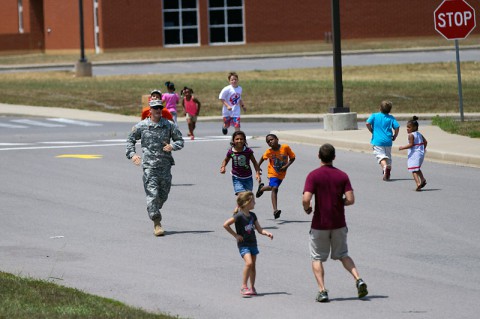 Pvt. Adam Grine, a native of Fostoria, Ohio, and a volunteer from Headquarters and Headquarters Detachment, 716th Military Police Battalion, 101st Sustainment Brigade, 101st Airborne Division, participates in a fun run with students during a back-to-school bash Saturday, at West Creek Elementary School in Clarksville, Tenn. Soldiers have volunteered at the school since it opened seven years ago. (Sgt. Leejay Lockhart, 101st Sustainment Brigade Public Affairs)