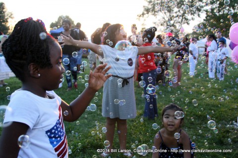 A young girl plays in the bubbles at the Tiffany's Spa booth in the Family Fun Zone