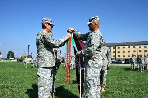 Col. George N. Appenzeller and Command Sgt. Major James Smith attach the Army Superior Unit Award ribbon on the Fort Campbell Warrior Transition Battalion colors Friday, Sept. 5, 2014. The Battalion earned this award for their actions in support of the combat operations in Afghanistan from October 1, 2014 through September 30, 2012