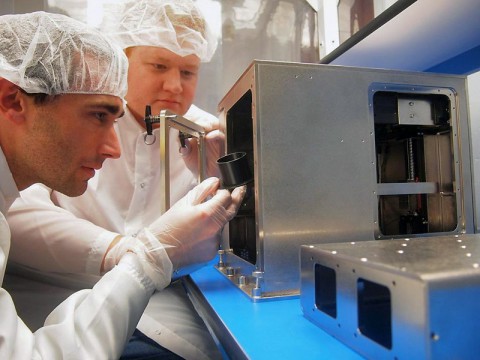 Mike Snyder and Jason Dunn, both from Made In Space, assemble the 3-D printer that will fly to the International Space Station in the company's cleanroom. (Made In Space)