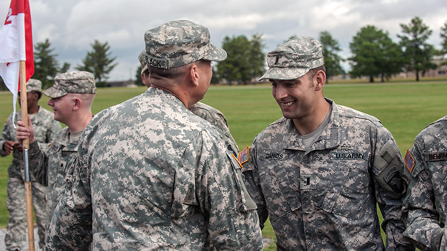 First Lt. Kenneth Danos, aeromedical-evacuation pilot, Company C, 6th Battalion, 101st Combat Aviation Brigade, 101st Airborne Division (Air Assault), is congratulated by Command Sgt. Maj. Stuart C. O'Black, command sergeant major, 101st CAB, after receiving his expert field medical badge, here, Oct. 3, 2014. Danos was the honor graduate, receiving zero no-gos during his testing phase. (Sgt. Duncan Brennan, 101st CAB Public Affairs)