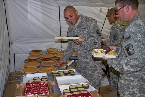 Soldiers with Task Force Lifeliner, Joint Forces Command – United Assistance dive into one of the many pies and desserts offered in the dining facility at brigade support area in Buchanan, Liberia, Nov. 27, 2014. (Sgt. 1st Class Mary Mittlesteadt, 101st Sustainment Brigade Public Affairs)