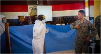 Senior Airman Grant Novotnak, an aerospace medical technician, shows local health care workers how to properly proceed through decontamination and removal of their personal protective equipment in Buchanan City, Nov. 21, 2014. The mobile training team is comprised of service members from the Army, Navy and Air Force. Operation United Assistance is a Department of Defense operation in Liberia to provide logistics, training and engineering support to U.S. Agency for International Development-led efforts to contain the Ebola virus outbreak in western Africa. (Staff Sgt. Terrance D. Rhodes/U.S. Army)