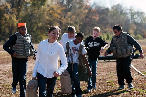 Students from West Creek Middle School in Clarksville, Tenn., carry water cans as part of an obstacle course set up by the 551st Military Police Company, 716th Military Police Battalion, 16th Military Police Brigade, supported by the 101st Sustainment Brigade, 101st Airborne Division, for a Veterans Day event Nov. 7 at West Creek Middle School. (U.S. Army photo by Sgt. Leejay Lockhart)