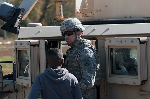 Spc. David Ortiz, a Military Police Soldier with the 551st Military Police Company, 716th Military Police Battalion, 16th Military Police Brigade, supported by the 101st Sustainment Brigade, 101st Airborne Division, answers questions Roman, a student at West Creek Middle School, asked about the M1151 Humvee Nov. 7 at West Creek Middle School in Clarksville, Tenn.  (U.S. Army photo by Sgt. Leejay Lockhart)