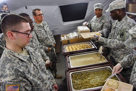 Soldiers wait in line for the first hot meal served on Barclay Training Center Nov. 9, 2014. Since arriving more than three weeks ago, service members have only consumed Meals, Ready-to-Eat. The hot meal gave service members something different to look forward to and boosted morale throughout the camp.  (Staff Sgt. Terrance D. Rhodes)