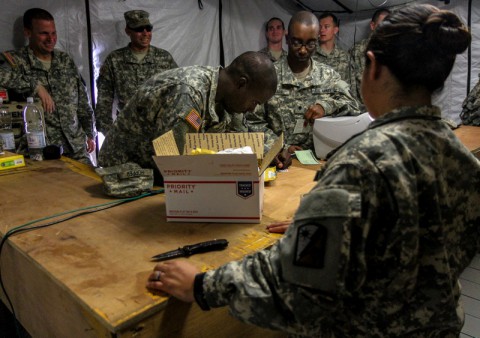 Spc. Guadalupe Shim, right, native of Dallas and postal specialist for the 18th Human Resources Company, 82nd Special Troops Battalion, 82nd Sustainment Brigade, assists Spc. Randritz Hopper, center, native of Shelby, N.C., and medical logistics specialist for the 583rd Medical Logistics Company, 1st Medical Brigade, with a package that he is sending back to the U.S. from Roberts International Airport, Monrovia, Liberia, on Dec. 22, 2014. The post office at Roberts International Airport is the first fully functional Army post office to open in Liberia, allowing Soldiers deployed to Liberia in support of Joint Forces Command – United Assistance to buy flat rate boxes, apply postage and send their own care packages back home to their family and friends in the states. Operation United Assistance is a Department of Defense operation in Liberia to provide logistics, training and engineering support to U.S. Agency for International Development-led efforts to contain the Ebola virus outbreak in western Africa. (Spc. Caitlyn Byrne/U.S. Army)