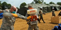 Capt. Scott Mueller, left, executive officer, 61st Preventative Medicine Detachment, 86th Combat Support Hospital, Fort Campbell, Ky., and Pfc. Garrett Perlinger, right, preventative medicine specialist, also with 61st Preventative Medicine Detachment, start up a motorized sprayer in preparation to spray insecticide around the area where a health clinic is currently being built in Gbediah, Liberia (Sgt. Matt Britton/U.S. Army)