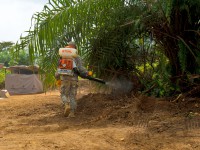 Pfc. Garret Perlinger, preventative medicine specialist, 61st Preventative Medicine Detachment, 86th Combat Support Hospital, Fort Campbell, Ky., sprays insecticide around the area where a health clinic is currently being built in Gbediah, Liberia (Sgt. Matt Britton/U.S. Army)