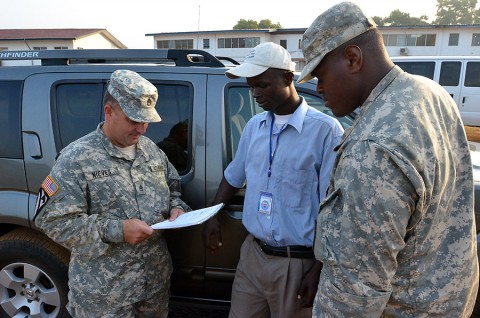 From left, Staff Sgt. Jose Nieves, a Bayamon, Puerto Rico, native and movement noncommissioned officer for Headquarters and Headquarters Company, 36th Engineer Brigade, talks to Haji A. Sheriff, a Liberia, Monrovia native and a driver, about his routes before he goes out on a mission to Buchanan, Liberia, Dec. 27, 2014, from the National Police Training Academy, Paynesville, Liberia, during Operation United Assistance. (Sgt. Ange Desinor, 13th Public Affairs Detachment)