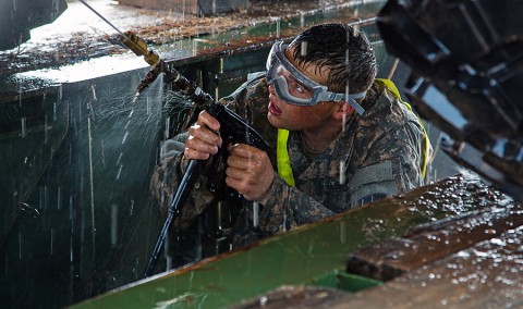 Spc. Michael Saucier a truck driver with the 101st Sustainment Brigade, Task Force Lifeliner, Joint Forces Command â?? United Assistance, pressure washes the bottom of a Light Medium Tactical Vehicle at Buchanan, Liberia, Jan. 28, 2015. (Specialist Rashene Mincy, 55th Signal Company (Combat Camera)