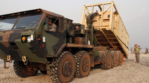 Pvt. 1st Class Joshua Bone with the 227th Quartermaster Company, 129th Combat Sustainment Support Battalion, 101st Sustainment Brigade, Task Force Lifeliners, Joint Task Force - United Assistance, offloads a tactical water purification system (TWPS) at a waterfront in Buchanan, Liberia, on Jan. 8, 2015. The TWPS is a logistical capability that is used to provide clean water for forces supporting Operation United Assistance.  (Sgt. 1st Class Mary Rose Mittlesteadt, 101st Sustainment Brigade)