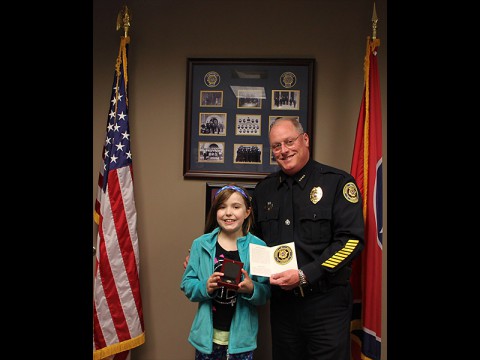 Clarksville Police Deputy Chief Parr presents Jenna King with the CPD Coin and the CPD Patch.