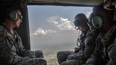 Maj. Gen. Gary Volesky, left, commander of Joint Forces Command – United Assistance, Pfc. Michael Major, center, a vehicle mechanic attached to the 1st Area Medical Laboratory, and Sgt. Elijah Jones, a power generation equipment repairer attached to the Company D, 82nd Civil Affairs Battalion, fly over Monrovia, Liberia, in a UH-60 Black Hawk Helicopter, Jan. 30, 2015. (Spc. Rashene Mincy, 55th Signal Company (Combat Camera))