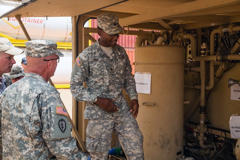 Spc. Darius Miles, right, a water treatment specialist, assigned to Task Force Lifeliner, 101st Sustainment Brigade, 101st Airborne Division (Air Assault), in support of Joint Forces Command – United Assistance talks about the process of water purification to Brig. Gen. Frank Tate, left, the deputy commanding general for support, JFC-UA Jan. 2, 2015, in Buchanan, Liberia. (Spc. Rashene Mincy, 55th Signal Company (Combat Camera))