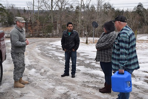 Maj. Colby Tippens delivers a can of kerosene to a family in need in Monterey, Tennessee.