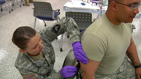 Spec. Heather Rogers, medic from 1-33 Cavalry with the 3rd Brigade Combat Team, administers the MMR vaccine to Sgt. Kyle Allison, assigned to the Intelligent & Sustainment Co., 101st Headquarter and Headquarter Battalion, 101st Airborne Division, during a two-day post-wide Pandemic Exercise held at the Soldier Readiness Processing Center March 25 and 26. (BACH)