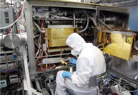 A Sample Analysis at Mars (SAM) team member at NASA's Goddard Space Flight Center in Maryland prepares the SAM testbed for an experiment. This test copy of SAM is inside a chamber that can model the pressure and temperature environment that SAM sees inside NASA's Curiosity rover on Mars. (NASA/GSFC)