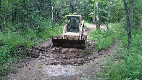 Spc. Jordan Seui, a horizontal construction engineer, with Company A, 39th Brigade Engineer Battalion, 2nd Brigade Combat Team, 101st Airborne Division (Air Assault), performs maintenance with an S150 Bobcat, for on the Warrior Challenge Obstacle and Mud Run course, at Fort Campbell, Ky., June 17, 2015. (Sgt. 1st Class Matthew Shane, 39th Brigade Engineer Battalion BEB, 2nd Brigade Combat Team BCT, 101st Airborne Division (Air Assault))