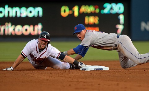 Atlanta Braves Chris Johnson (23) slides safely into second base ahead of the tag by New York Mets shortstop Wilmer Flores (4) on a fielding error in   the fourth inning of their game at Turner Field. (Jason Getz-USA TODAY Sports)